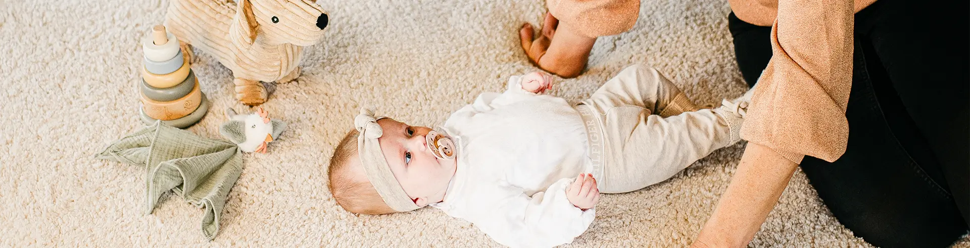 een baby die ligt op het speelkleed van Teddy days.